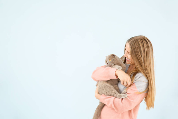 Beautiful woman with cute cat on color background - Photo, Image