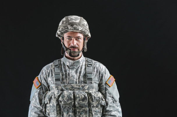 Soldaat in camouflage op donkere achtergrond - Foto, afbeelding