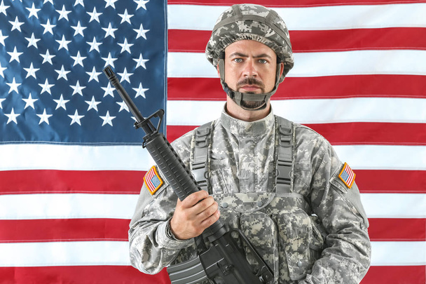 Soldat mit Sturmgewehr und US-Nationalflagge im Hintergrund - Foto, Bild