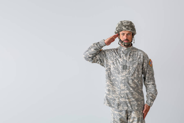 Saluting soldier on light background - Photo, Image