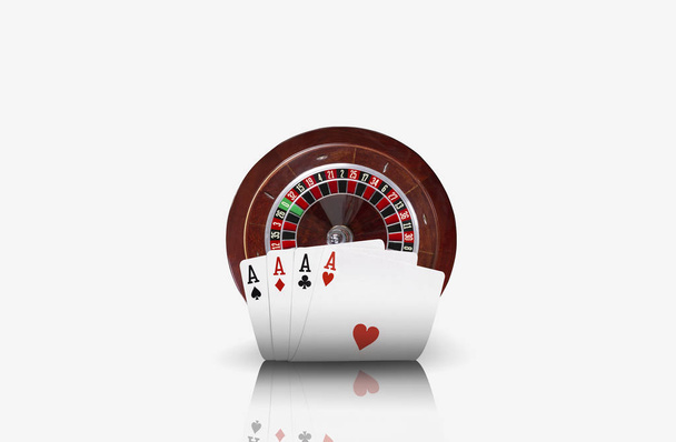 Foto de cerca de cuatro ases delante de una ruleta marrón, aislada sobre fondo blanco. Jugando cartas. Juegos de azar entretenimiento
. - Foto, imagen