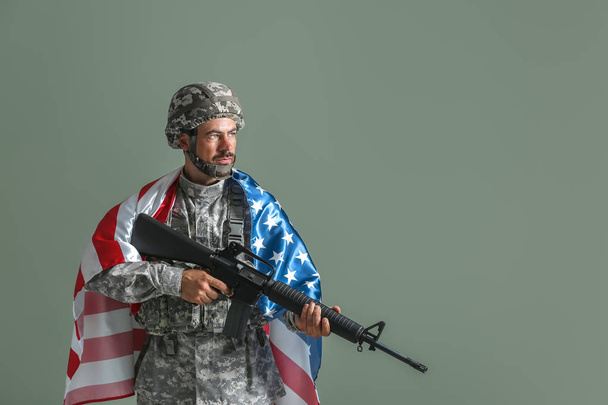 Voják s národní vlajkou USA a útočné pušky na barevné pozadí - Fotografie, Obrázek