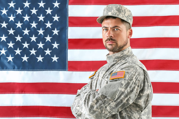 Żołnierz w kamuflażu z Narodową flagą USA na tle - Zdjęcie, obraz