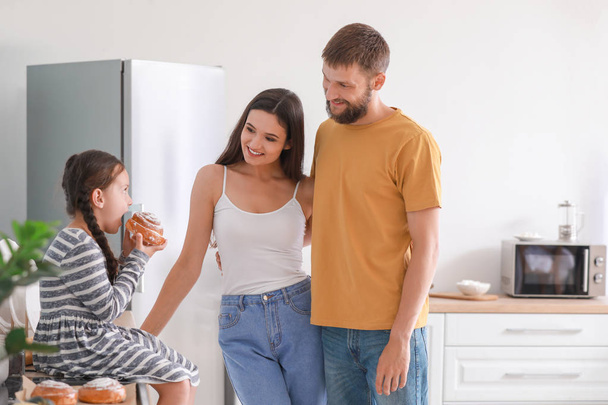 Young family with freshly baked buns in kitchen - Foto, Bild
