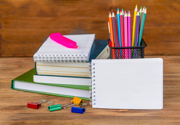 Back to school! School supplies, on wooden background. Alarm clock. Colored pencils. Pile of books.Mockup free. - Fotó, kép
