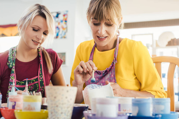 Women in DIY workshop coloring and decorating their own ceramic - Zdjęcie, obraz