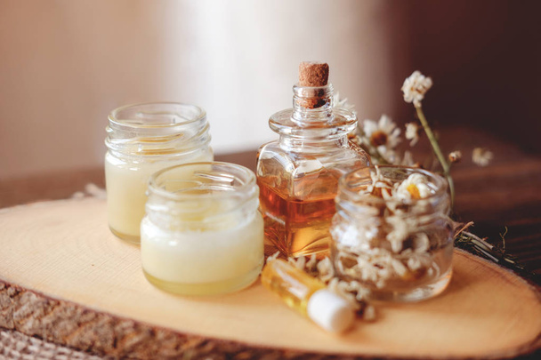 Crema de manos y bálsamo labial en un frasco de vidrio. Cosméticos orgánicos naturales con miel, cera y aceites
. - Foto, Imagen