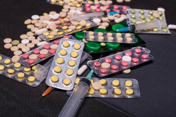 medicamentos antibióticos pílulas medicina / antibacterianos coloridos pílulas sobre fundo preto / pílula medicina. Ideia criativa. Drogas. Triste. Morre. Doença
 - Foto, Imagem