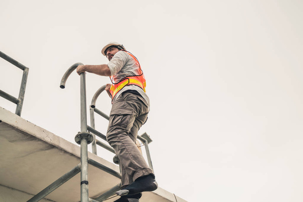Genç adam işçi ya da mühendis merdiveni tırman. - Fotoğraf, Görsel