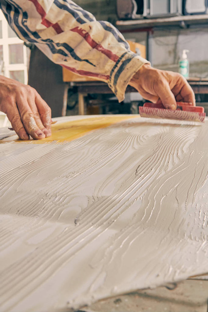 Artista usando pincel para hacer textura de madera artificial
. - Foto, Imagen