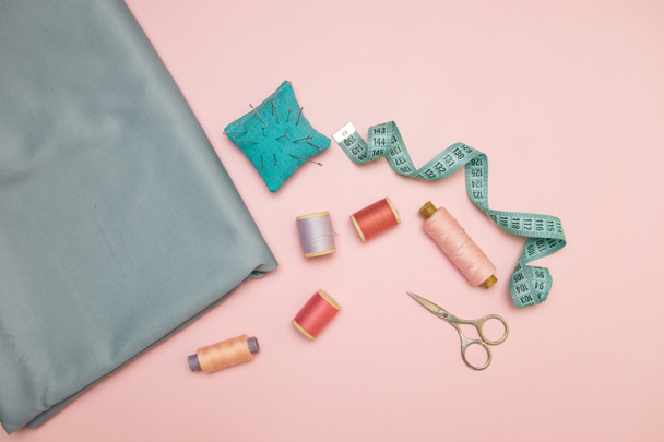 Herramientas de aguja, punto de aguja de punto para coser, tijeras y carretes de hilo de colores sobre un fondo rosa con espacio de copia para texto
 - Foto, Imagen