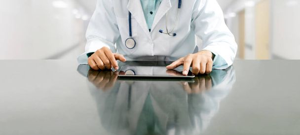 Лікар з планшетним комп'ютером в лікарняному офісі
. - Фото, зображення
