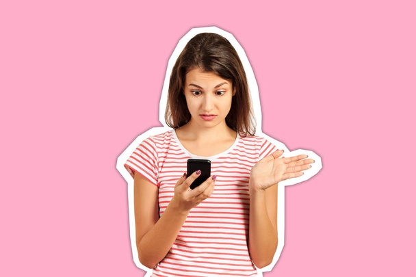 surprised student girl dressed in a striped top, embarrassed puzzled look in holding a smartphone in her hands, bewildered. emotional girl Magazine collage style with trendy color - Photo, Image