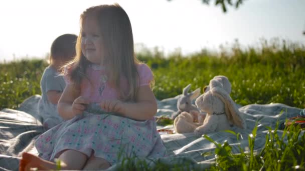 Két gyermek nővér ül egy piknik terjed. - Felvétel, videó