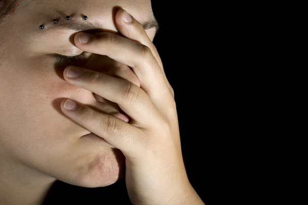 triest meisje met hand op haar gezicht - Foto, afbeelding