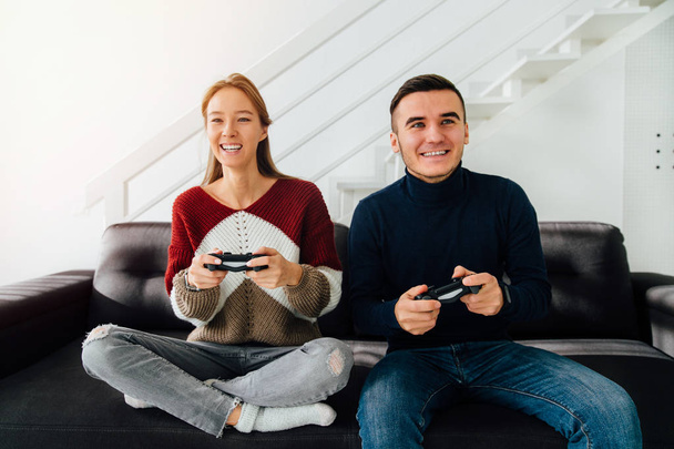 Front view of a beautiful couple playing computer games at home - Foto, Imagem
