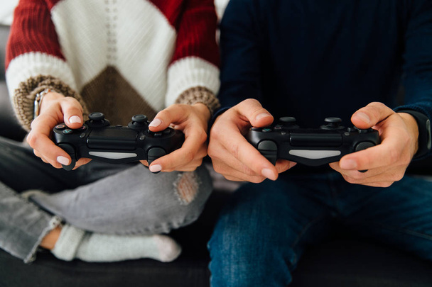 Young couple holding game joysticks, close-up view. - Foto, afbeelding