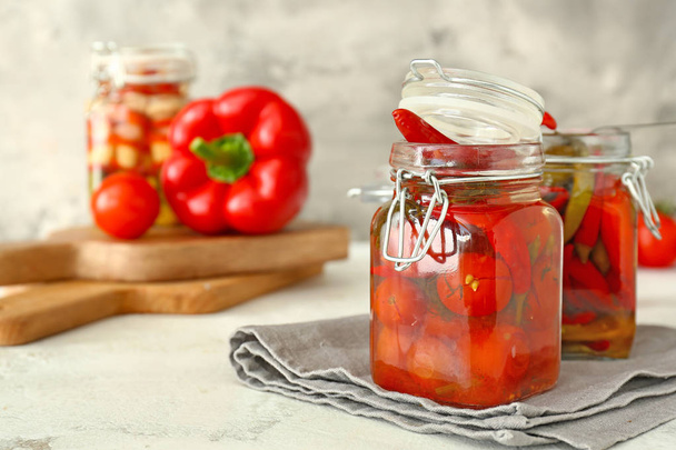 Potten met Ingeblikte tomaten en Chili peper op tafel - Foto, afbeelding