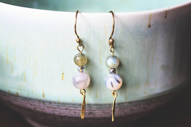 Natural beads earrings hanging on pottery - 写真・画像