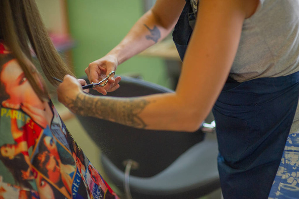 Peluquería estilista hace un peinado para una niña linda en un salón de belleza. Peluquería, corte de pelo
. - Foto, imagen