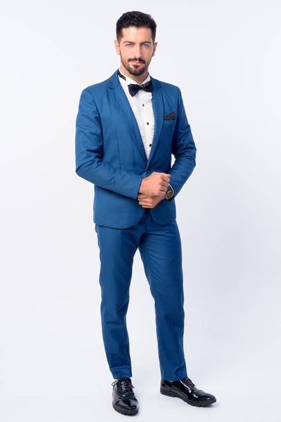 Full body shot of young handsome bearded businessman in blue suit - 写真・画像