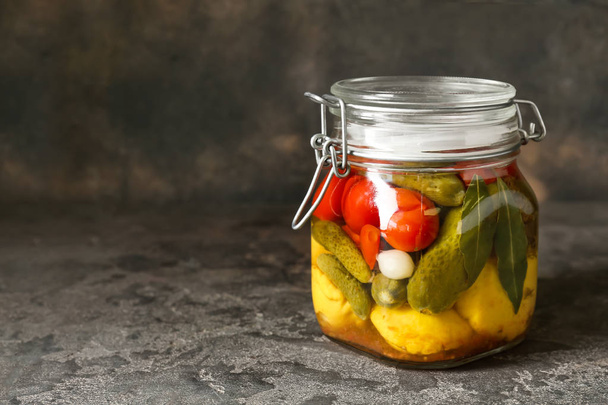 Jar with different canned vegetables on grunge background - Photo, Image