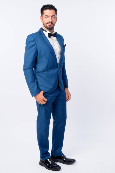 Full body shot of young handsome bearded businessman in blue suit - Photo, Image