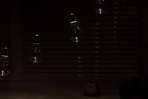 暗い背景にヴィンテージランプ電球の花輪 - 写真・画像