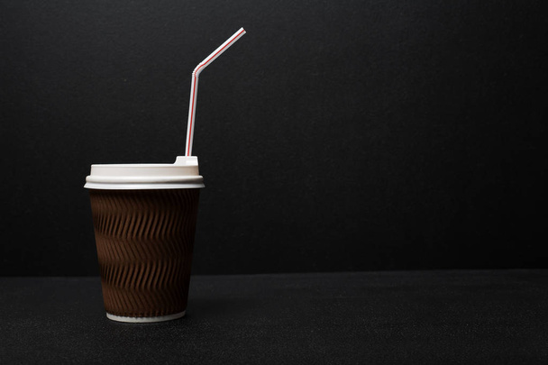 Крупный план одноразовой чашки кофе на черном фоне
 - Фото, изображение