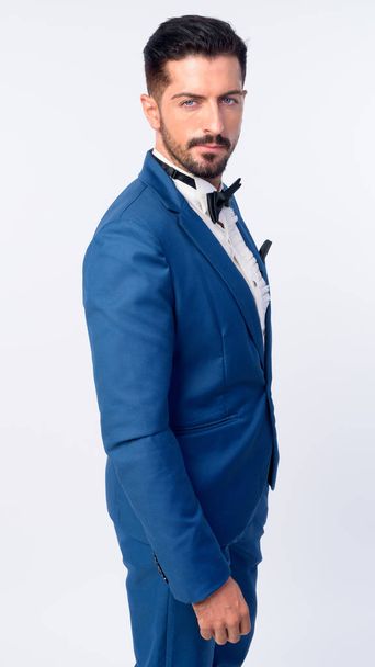 Portrait of young handsome bearded businessman in blue suit - 写真・画像