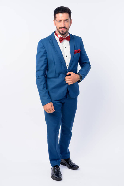 Full body shot of young handsome bearded businessman in blue suit - Foto, imagen