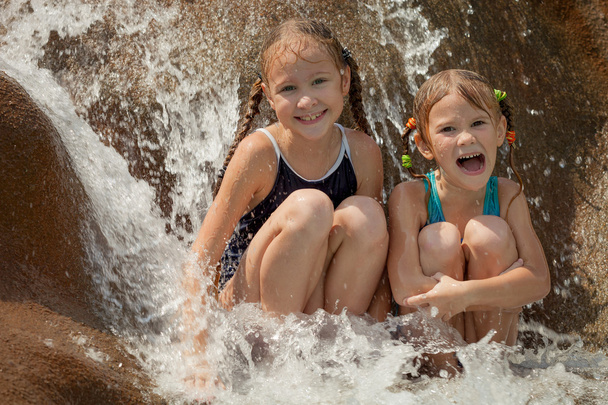 two happy little girls sitting near the pool - Foto, Imagen