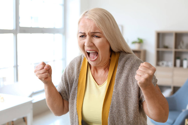 Mujer madura enojada en casa
 - Foto, imagen