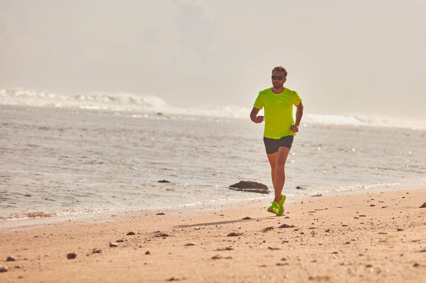 Hombre corriendo / corriendo en una playa tropical exótica
. - Foto, Imagen