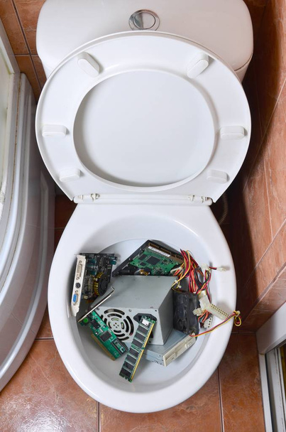 Stare i nieużywane szczegóły komputera są poddawane recyklingowi w misce toaletowej - Zdjęcie, obraz