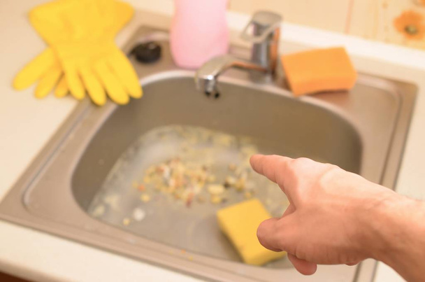 Pointes de main à l'évier de cuisine sale avec de nombreuses particules de nourriture avant le nettoyage
 - Photo, image