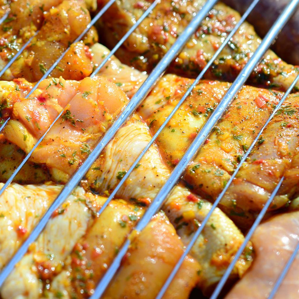 Marinated chicken legs on hot BBQ charcoal field grill - Photo, Image