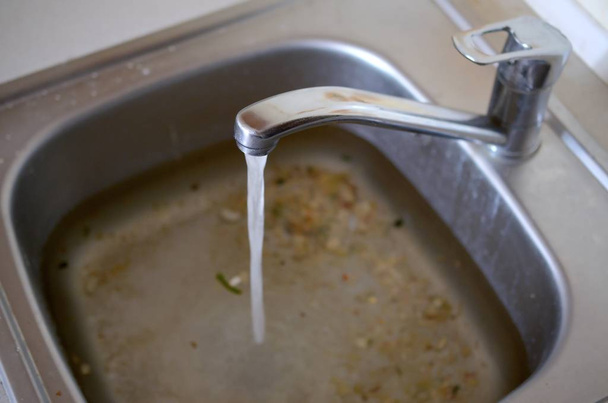 Paslanmaz çelik lavabo fiş delik su ve gıda parçacıkları dolu yakın - Fotoğraf, Görsel