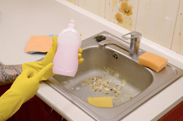 Detergente mostra detergente liquido bottiglia detergente a lavello sporco con particelle di cibo prima della pulizia
 - Foto, immagini