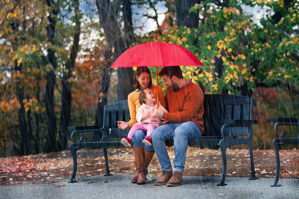 Young family enjoy in autumn rain - Foto, Imagem