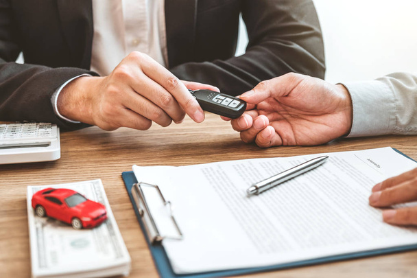 Sale agent giving Car key to customer and sign agreement contrac - Фото, зображення