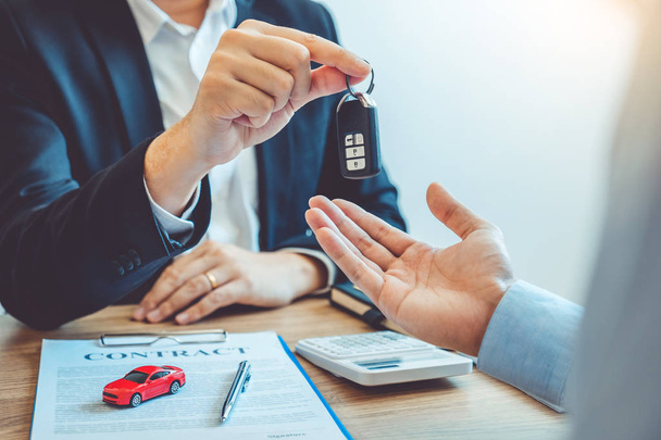 Sale agent giving Car key to customer and sign agreement contrac - 写真・画像