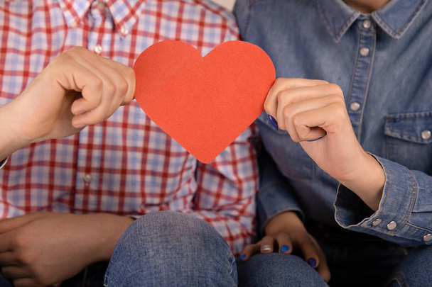Muž a ženská dvojice s červeným papírovým srdcem v izolaci. - Fotografie, Obrázek