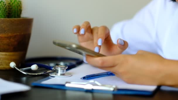 Slow motion. Close up Hands of professional doctor scrolling on smartphone, consulting patient online - Video