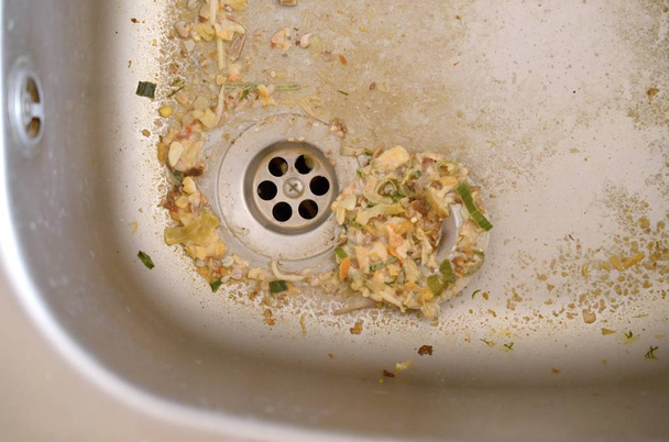 Close up on dirty clogging kitchen sink drain with food particles - Photo, Image