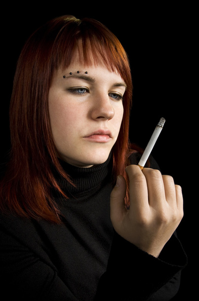 dziewczyna oglądając jej papierosa - Zdjęcie, obraz