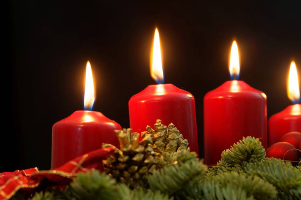rote Kerzen eines Adventskranzes mit Tannenzweigen - Foto, Bild