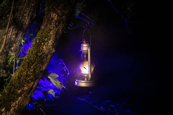 Horror-Halloween-Konzept. brennende alte Öllampe im Wald in der Nacht. Nächtliche Szenerie eines Albtraums. - Foto, Bild