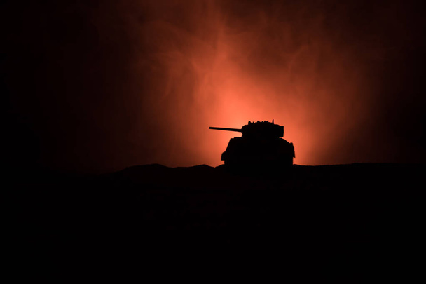 Військова концепція. Військові силуети бойових сцен на тлі війни туман небо, силует броньованого автомобіля нижче похмурих горизонт вночі. Напад сцени. Танки битви. - Фото, зображення