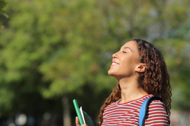 Happy mixed race student breathing fresh air in a park - Фото, зображення